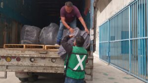 Trabajadores del SEDIF empacan cobertores destinados a las familias damnificadas por las lluvias.