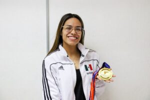 Claudia Romero, mostrando su más reciente medalla de oro